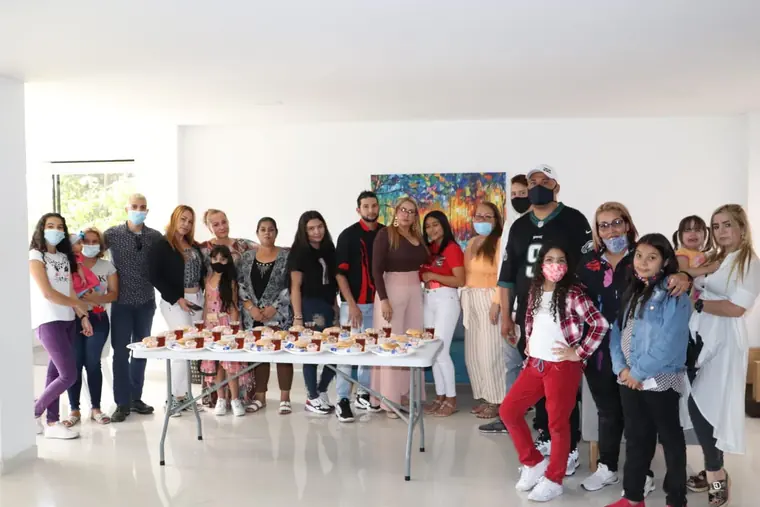 Familias y voluntarios reunidos junto a la mesa de refrigerios