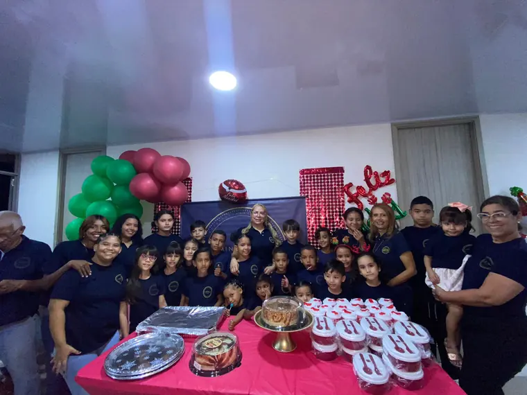 Niños y voluntarios junto a la mesa de la fiesta