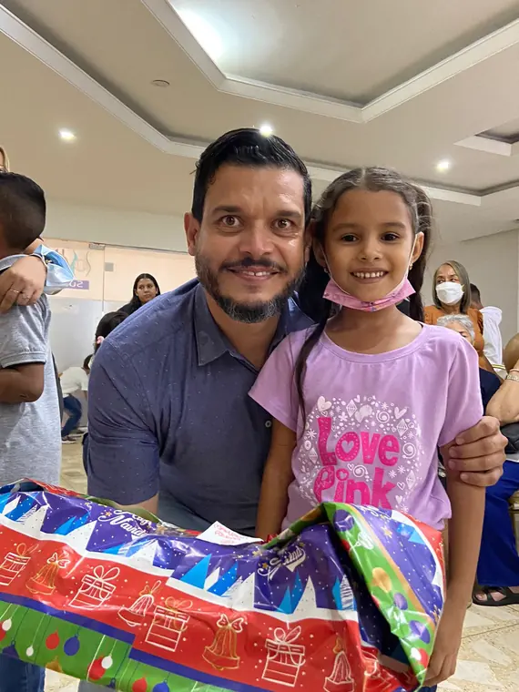 Hombre y niña sonriendo con un regalo