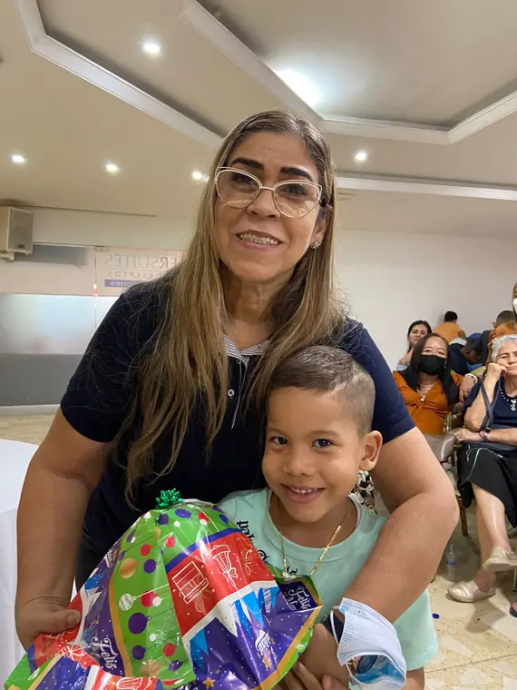 Mujer abrazando a un niño con sus regalos