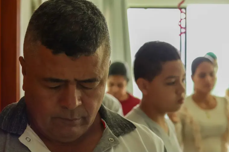 Hombre en oración junto a jóvenes