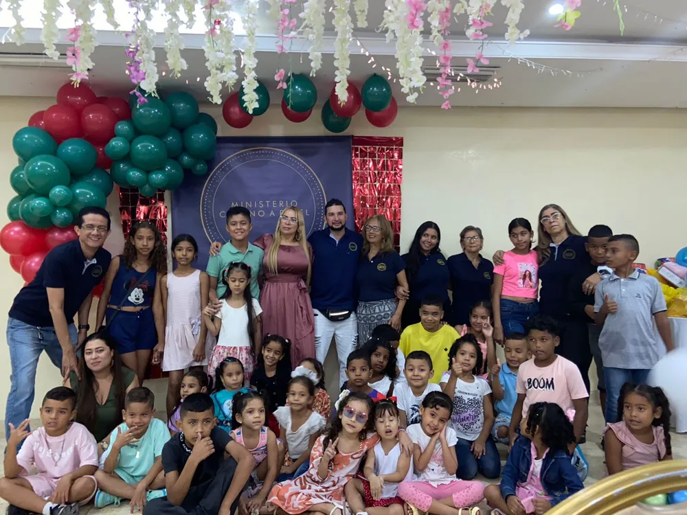 Grupo de niños y voluntarios posando juntos en una fiesta